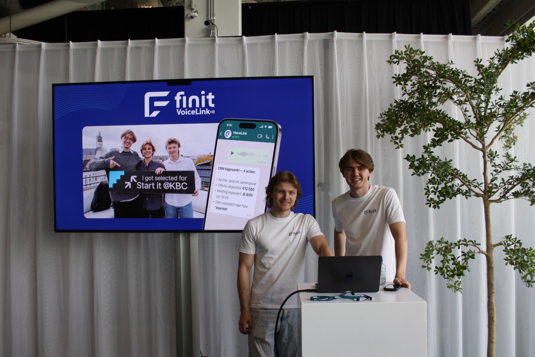 Het team van Finit Solutions op de stand van Start it @KBC, met VoiceLink op het scherm.